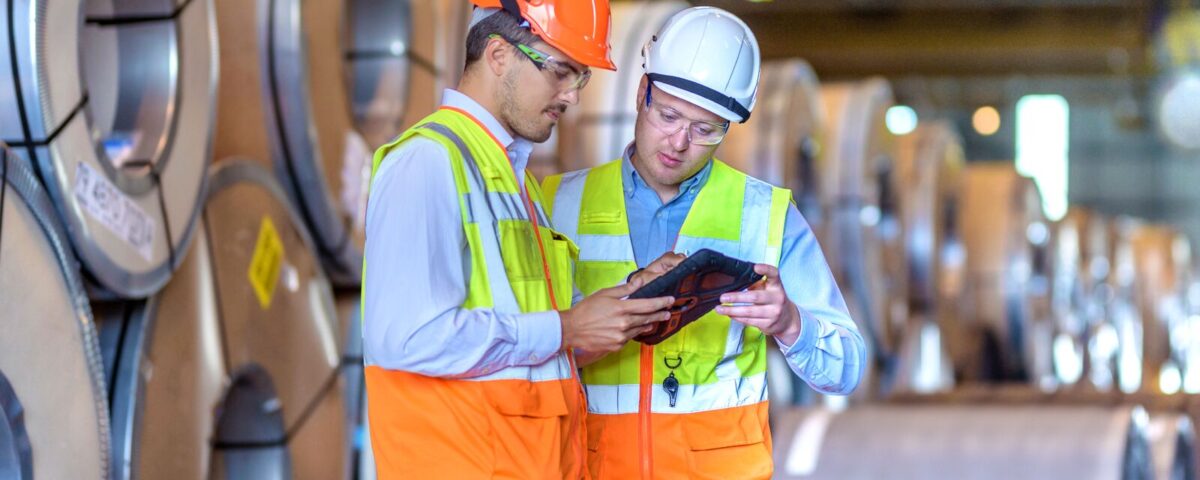 Inspector de seguridad usando tablet digital en fabrica de acero