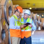 Inspector de seguridad usando tablet digital en fabrica de acero