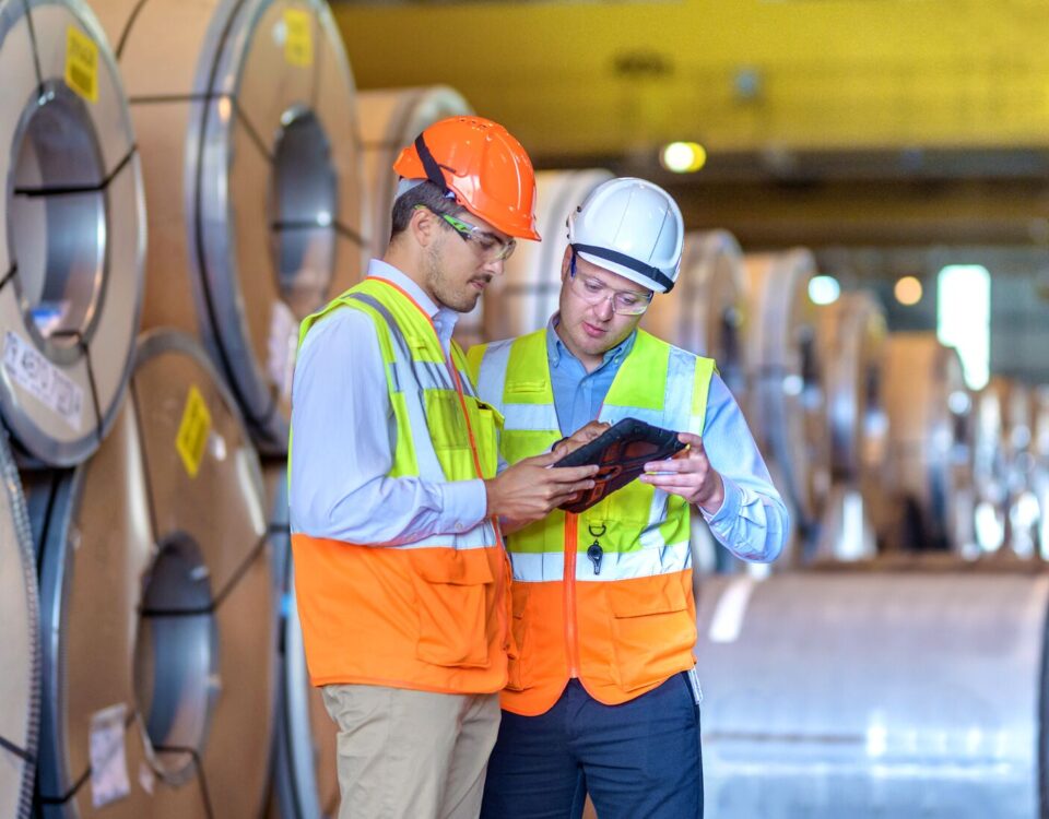 Inspector de seguridad usando tablet digital en fabrica de acero